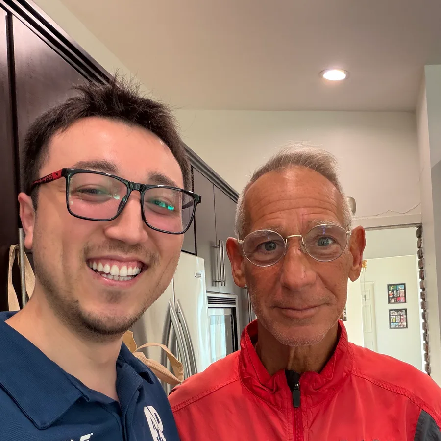 Joe, ApexPro’s founder, in a navy branded polo smiling with a customer in the customer’s kitchen next to a stainless refrigerator