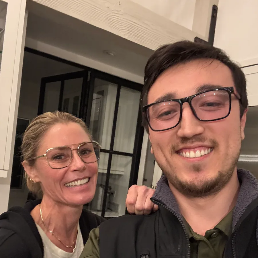 Joe, ApexPro’s founder, smiling with a customer in her kitchen, black-framed interior doors behind them