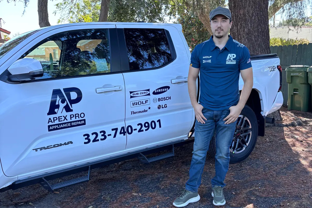 Joe, ApexPro’s founder, standing beside the branded white Toyota Tacoma service truck with the AP logo and phone number